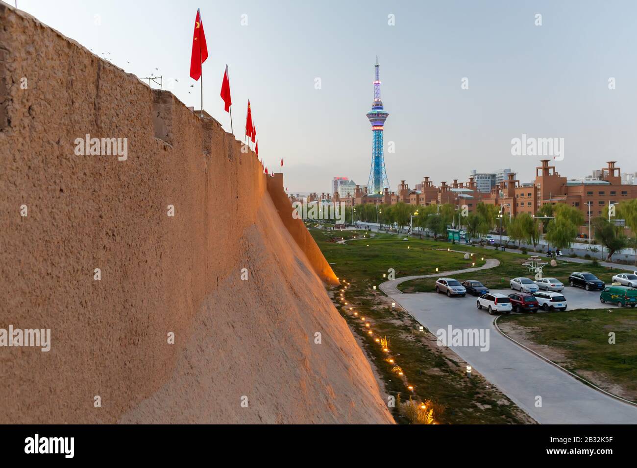 Vista lungo le mura della città vecchia di Kashgar verso la torre della televisione. A causa della festa nazionale le bandiere cinesi sono montate sulla parte superiore del muro. Foto Stock