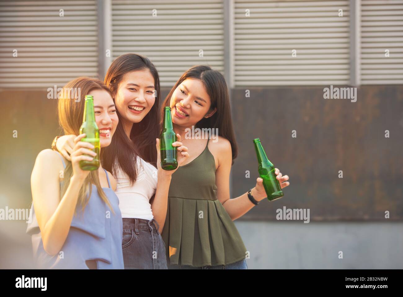 Gruppo di giovani amici asiatici donna hanno momento di felicità per celebrare festa di ballo con bottiglia di birra in mano in discoteca. Foto Stock