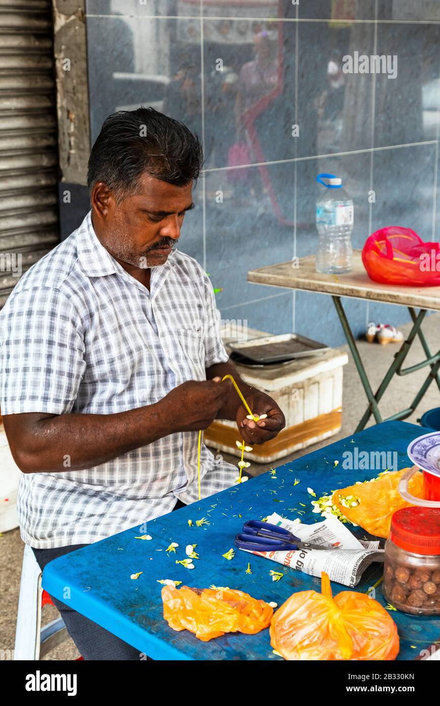 Uomo locale che fa ghirlande di fiori per la preghiera nel vicino Sri Mahamariamman Hindu Temple, Kuala Lumpur, Malesia, Asia Foto Stock