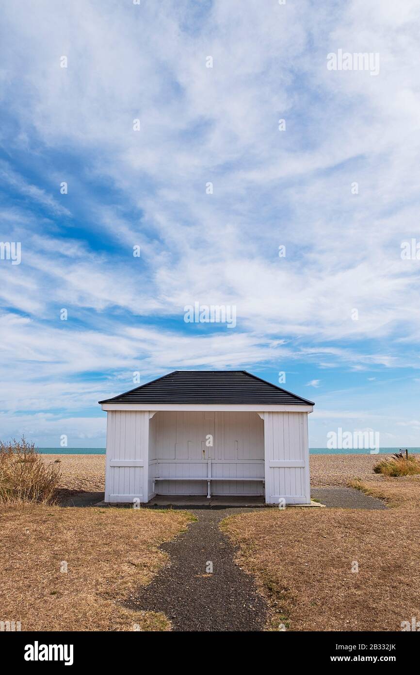 Rifugio in legno bianco sulla spiaggia di Aldeburgh, con un paesaggio di nuvole. Aldeburgh, Suffolk Regno Unito. Foto Stock