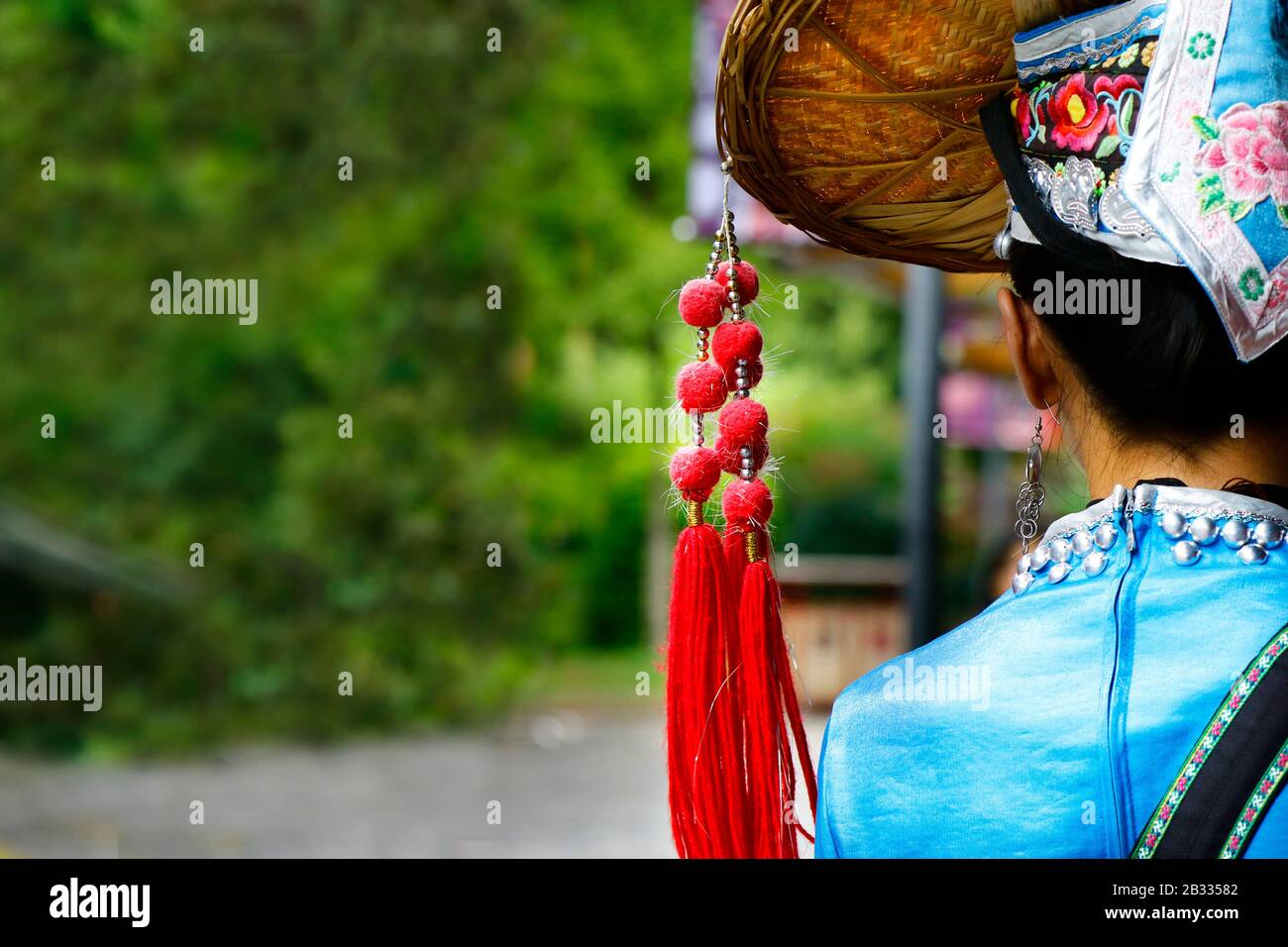 Vista dal retro della donna cinese con tradizionale costume e cappello minoranze etniche Foto Stock