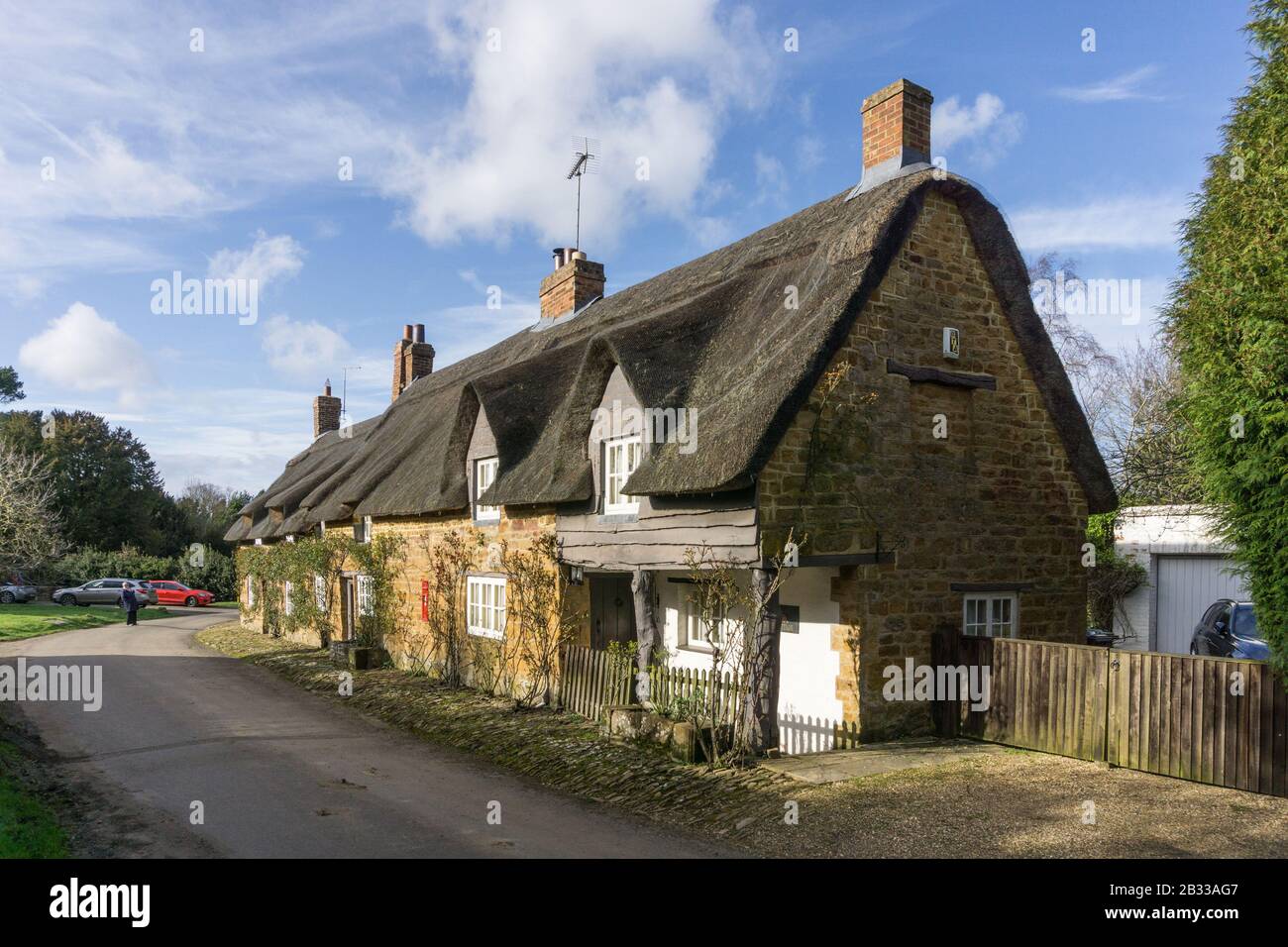 Fila di cottage terrazzati con tetto di paglia nella pittoresca frazione di Brockhall, Northamptonshire, Regno Unito Foto Stock