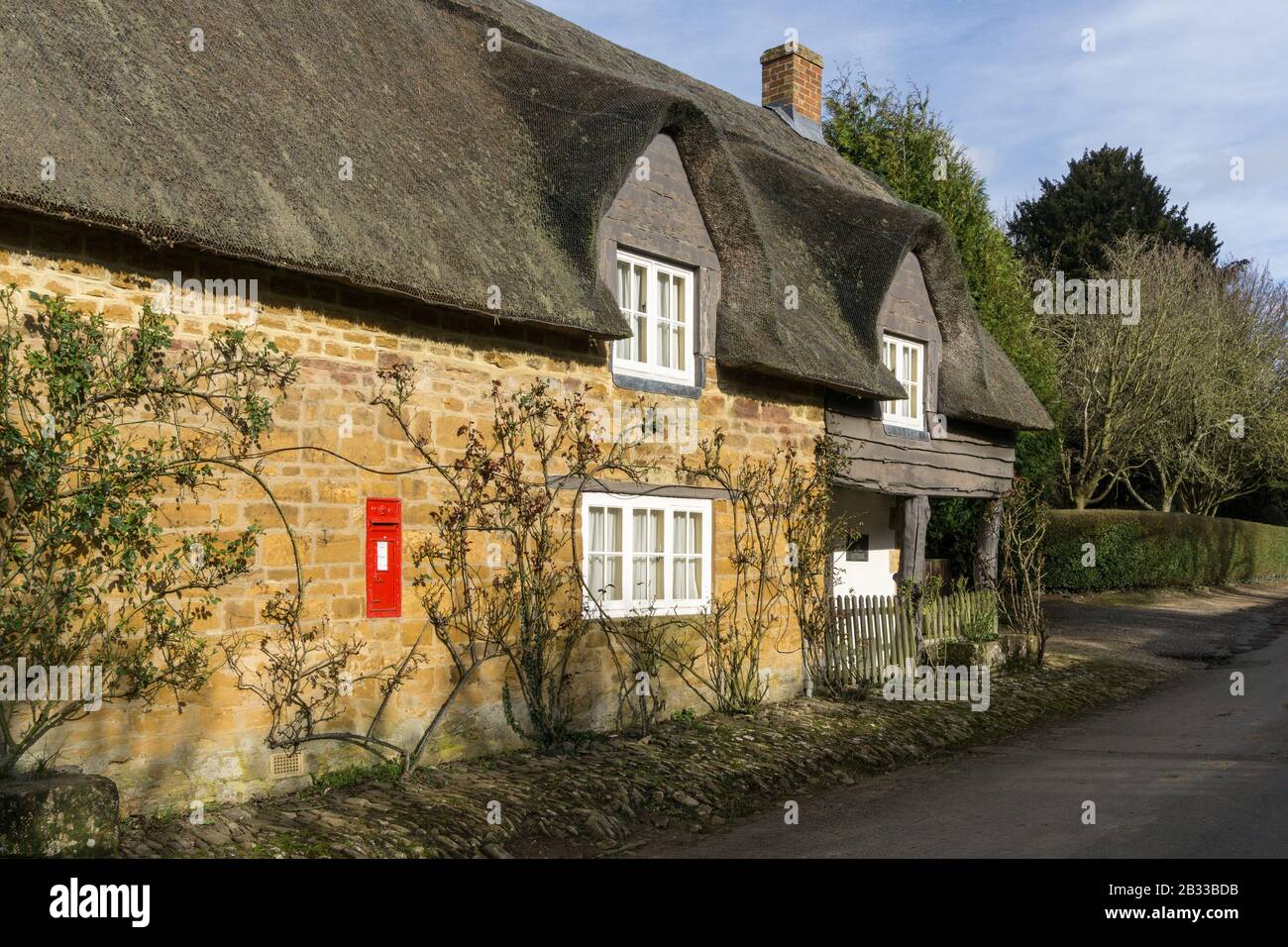Fila di cottage terrazzati con tetto di paglia nella pittoresca frazione di Brockhall, Northamptonshire, Regno Unito Foto Stock