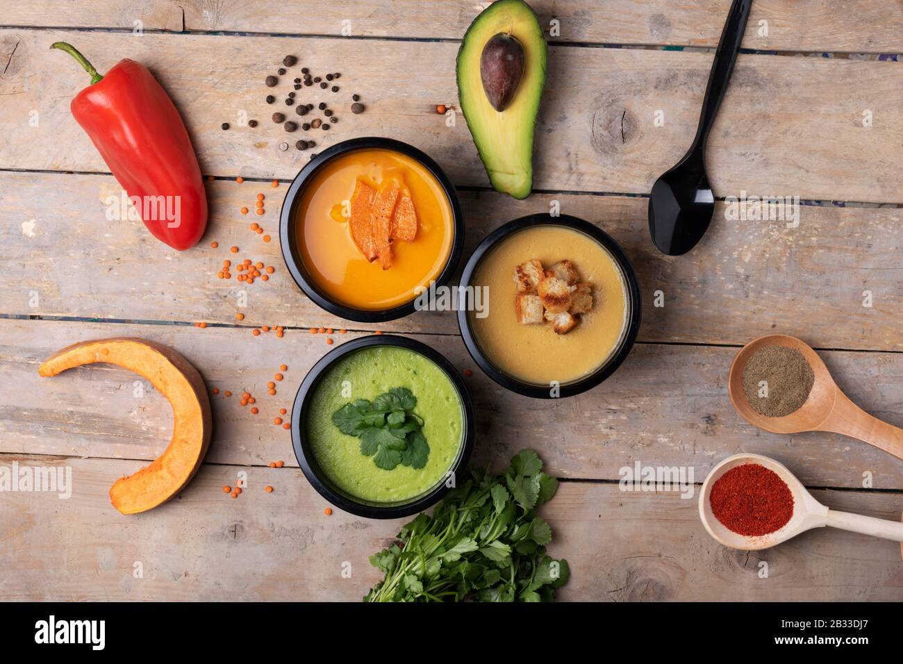 Un set di piatti. Zuppa di zucca, zuppa di crema di avocado, porridge di piselli. Vista piatta. Spazio libero per il testo. Rustico tavolo in legno Foto Stock