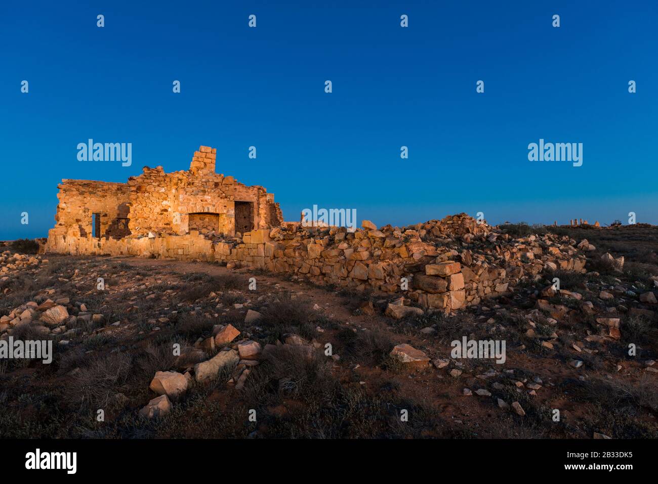 Un vecchio edificio in rovina e detriti sparsi nella città fantasma di farina nel nord dell'Australia del sud. Foto Stock