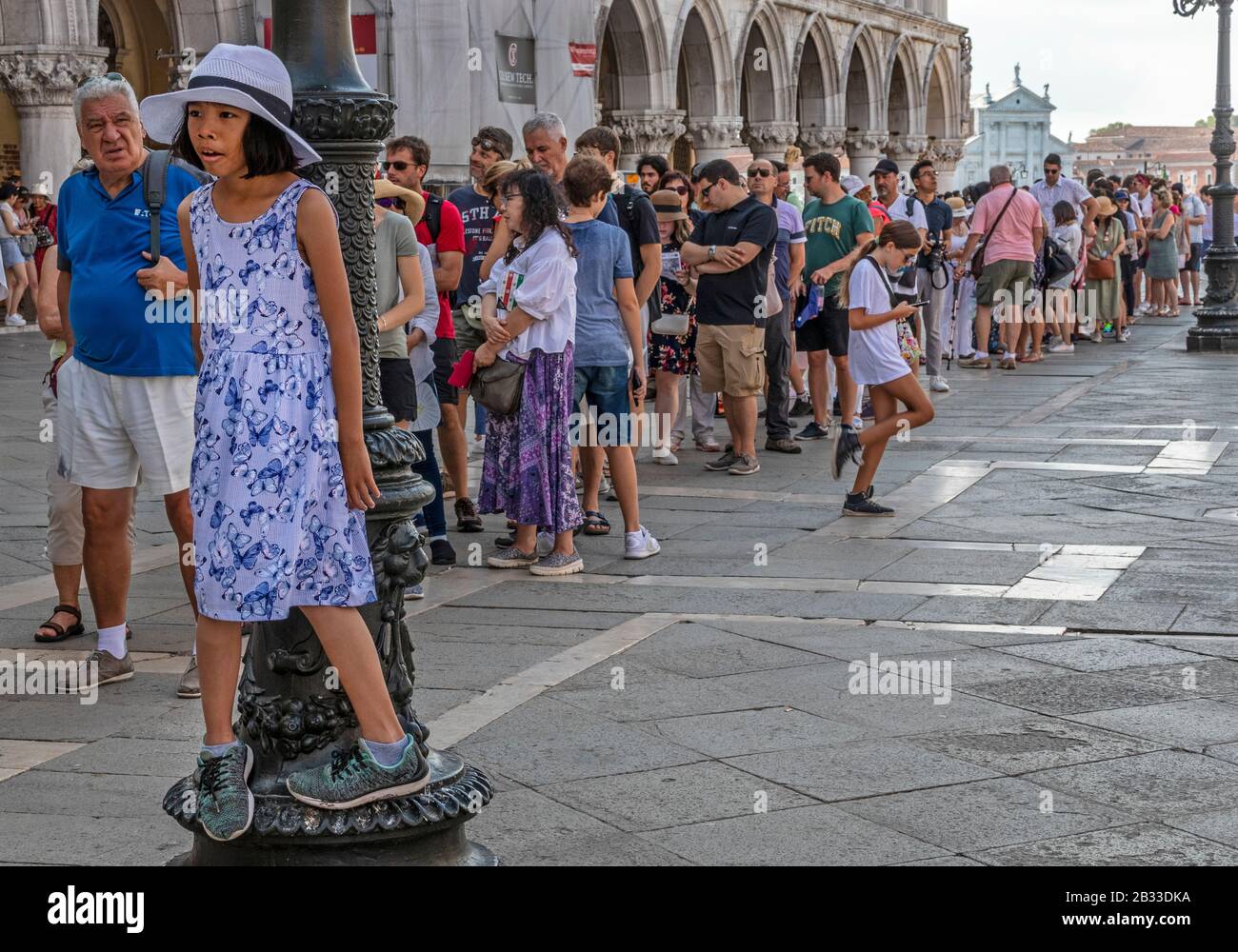 Giovane ragazza in attesa on line. Code, turismo di massa, Piazza San Marco, Venezia, Italia Foto Stock