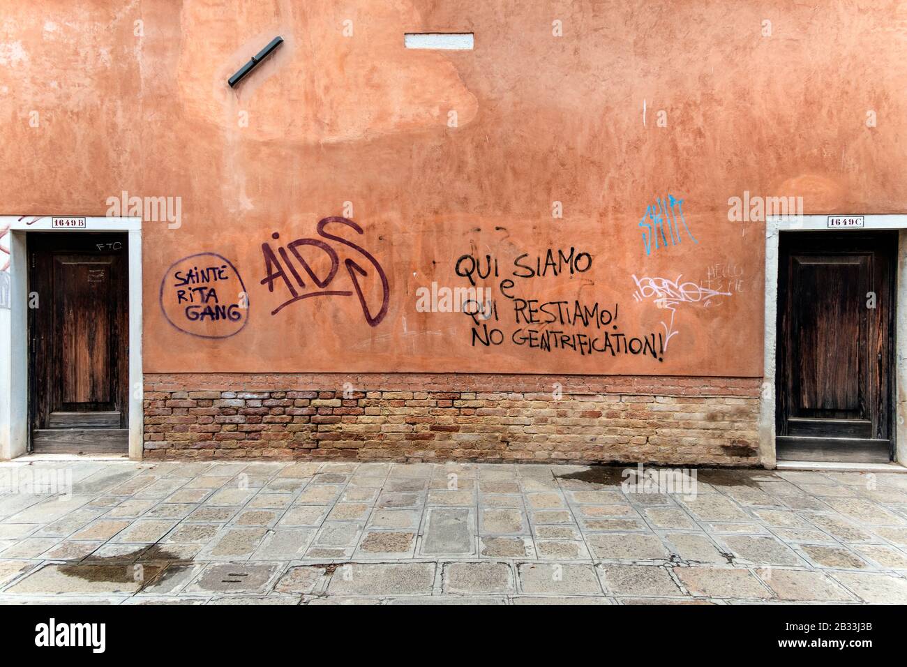 Graffiti sulle pareti della strada, dicendo 'qui siamo qui siamo noi stare, nessuna gentrificazione' Venezia, Italia Foto Stock