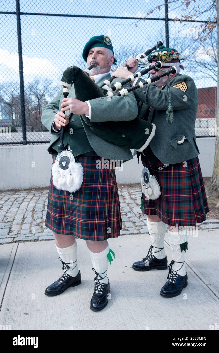 I membri della contea Cork Pipes & Drums sintonizzano i loro strumenti prima di marciare nella parata di San Patrizio a Sunnyside, Queens, New York. Foto Stock