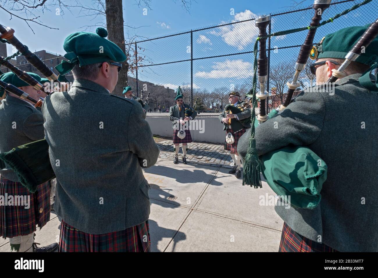 I membri della contea Cork Pipes & Drums ottengono in una certa pratica prima di marciare nella parata di giorno di San Patrick a Sunnyside, Queens, New York. Foto Stock