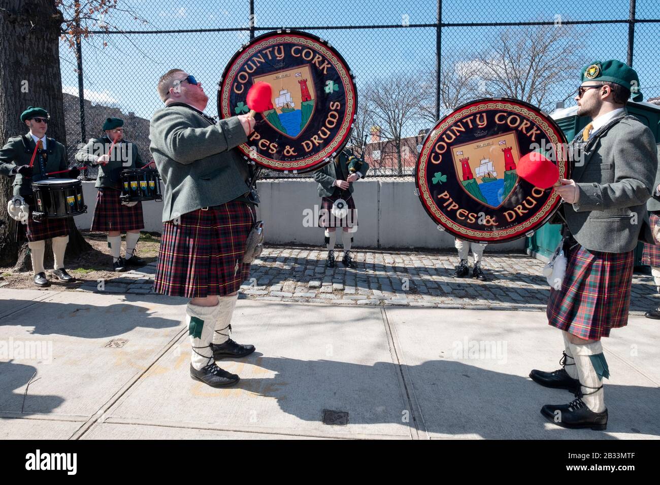 I membri della contea Cork Pipes & Drums ottengono in una certa pratica prima di marciare nella parata di giorno di San Patrick a Sunnyside, Queens, New York. Foto Stock