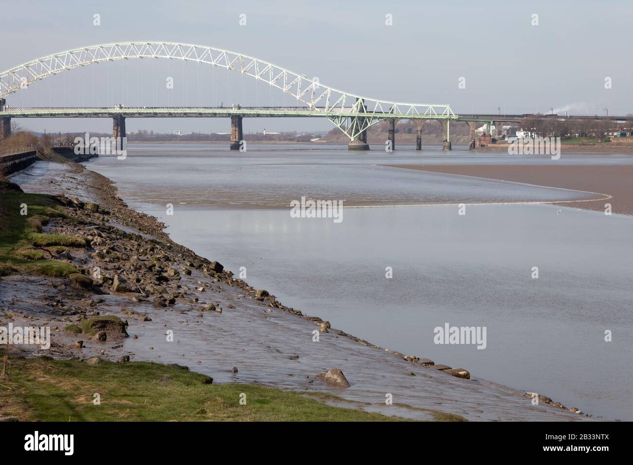Il Foro di Mersey Tidal visto dall'isola di Wigg a Runcorn, subito dopo aver superato il Ponte Jubilee d'Argento. Il foro a volte si verifica sulle maree più alte Foto Stock
