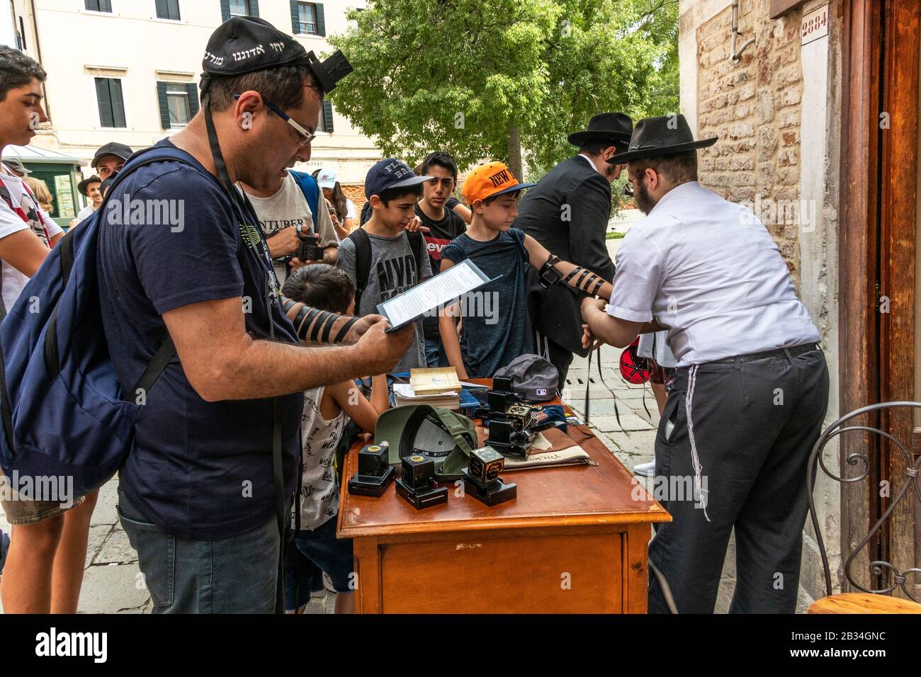 Visitatori ebrei che indossano Il Tefillin durante la preghiera del mattino nei giorni feriali, nel ghetto ebraico, campo de Ghetto Novo, Venezia, Italia, 2019. Foto Stock