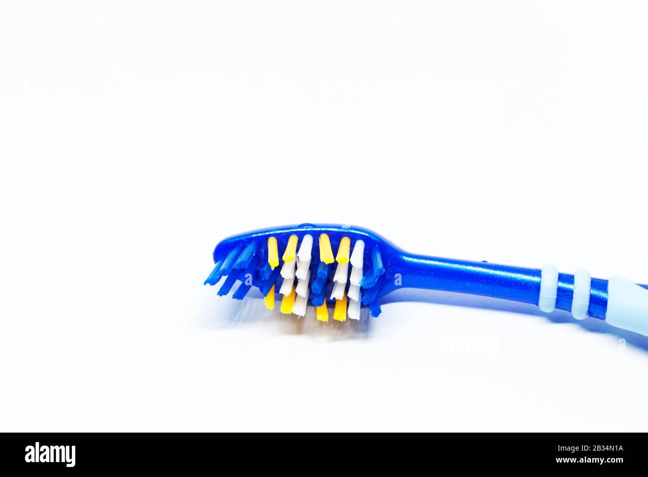 parte di uno spazzolino blu su sfondo bianco Foto Stock
