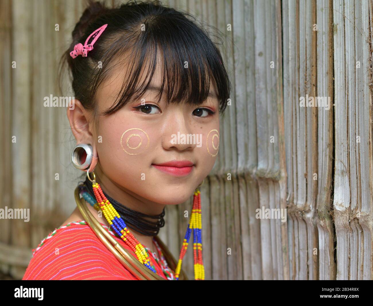 Bella Kayaw (Kayor) ragazza teen con tradizionale thanaka birmano viso cosmetici sulle sue guance e distintivo tribale tappi auricolari pone per la fotocamera. Foto Stock
