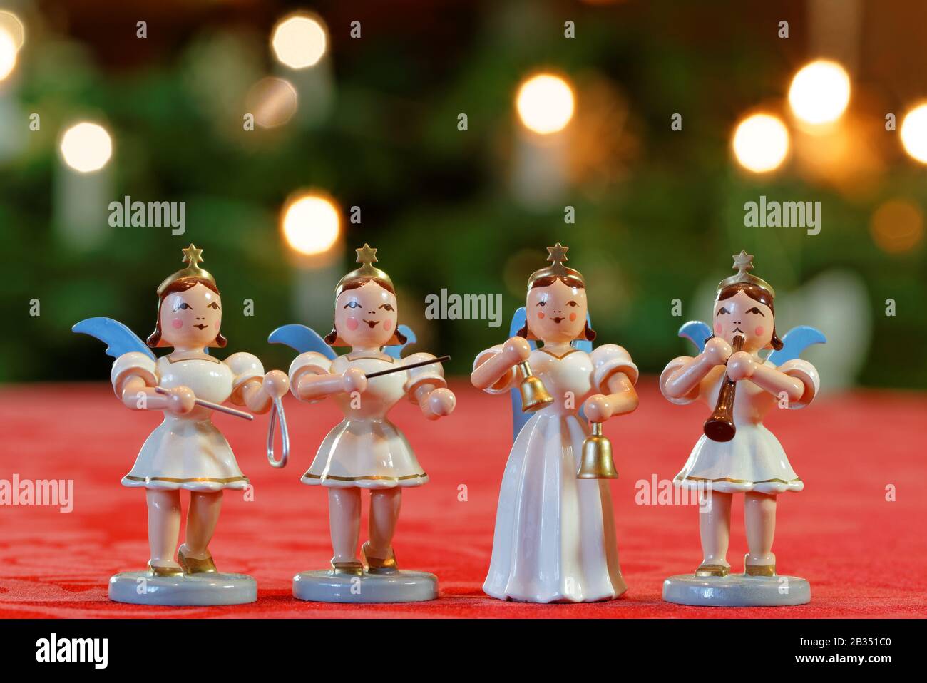 Concerto di Natale con Quattro Angeli: Quattro angeli decorazione che fanno musica di fronte a luci Christmassy Bokeh Foto Stock