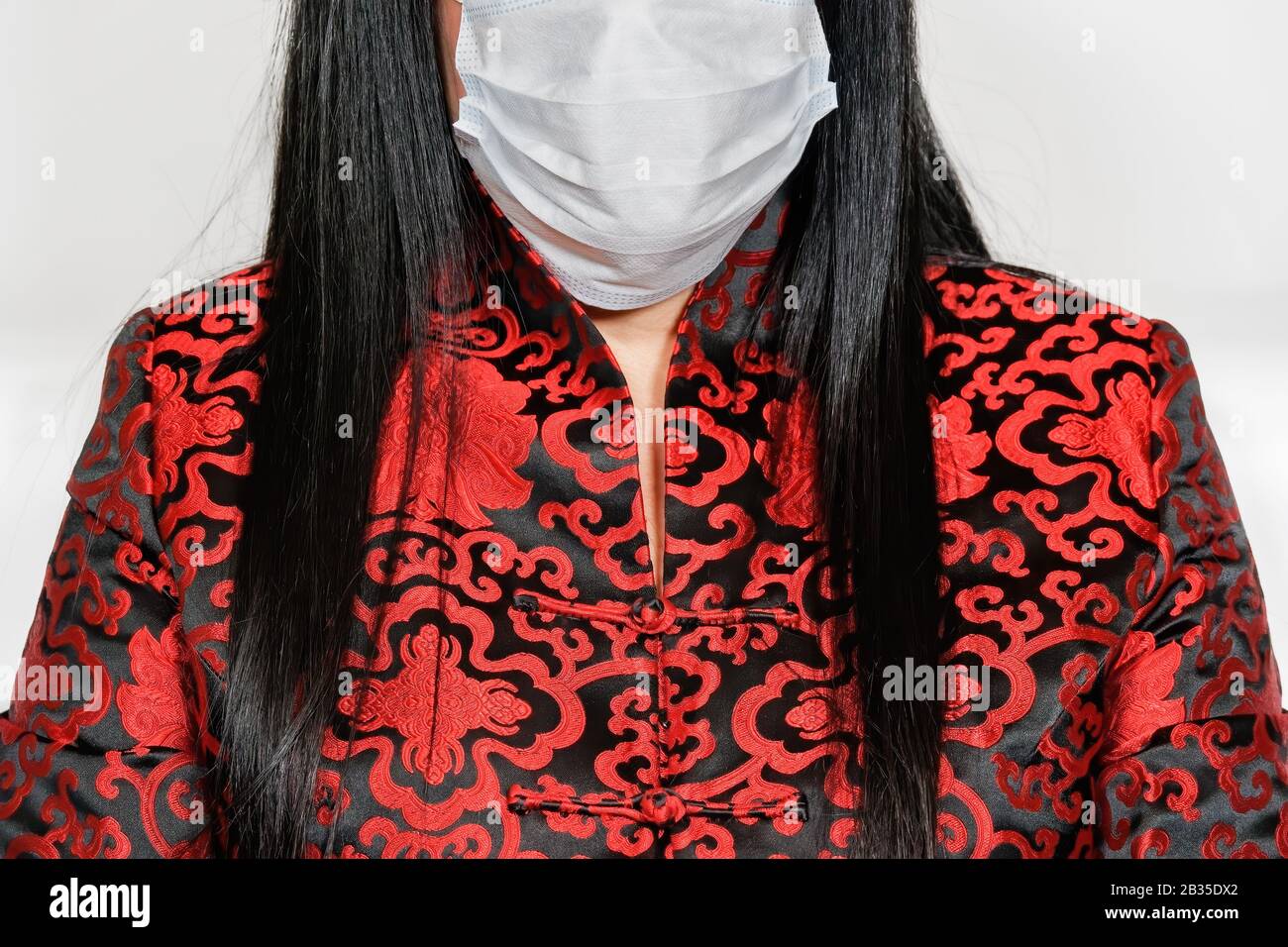 Coronavirus COVID-19 World Outbreak Concept con donna, vestita con abiti asiatici, indossando maschera facciale per proteggere dalle malattie respiratorie e del 2019-nCoV. Foto Stock