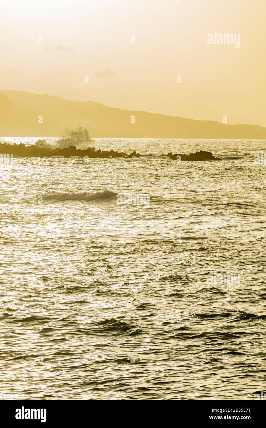 Marea e onde che arrivano in direzione di Punta Brava sulla spiaggia durante una calima a Playa Jardin, Puerto de la Cruz, Tenerife, Isole Canarie, Spagna, Foto Stock