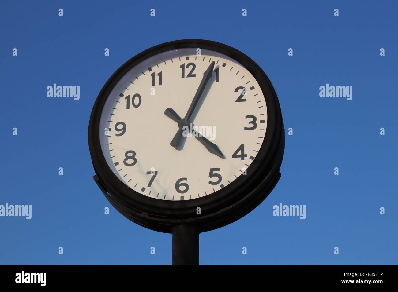 Orologio di strada in stile retrò su sfondo azzurro. Foto Stock