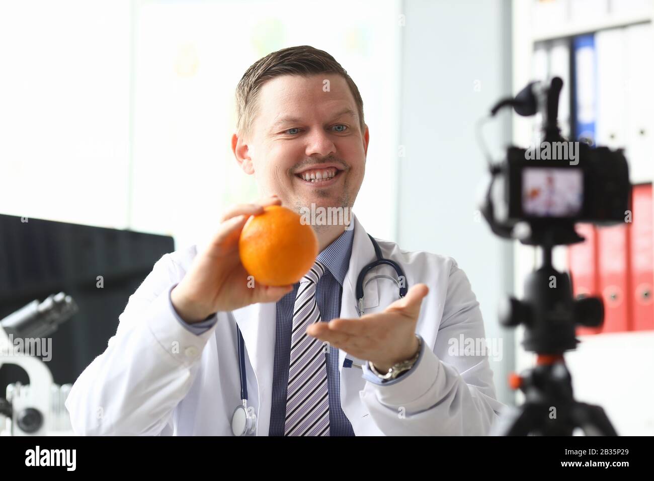Il medico nutrizionista parla di benefici arancione Foto Stock