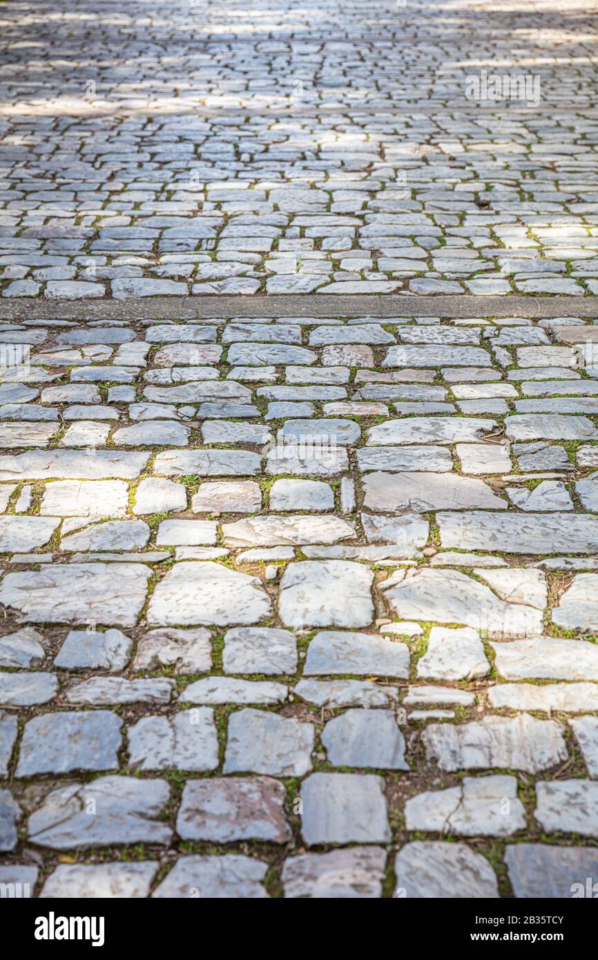 Sentiero pavimentato in marmo di pietra antica, fondo del sentiero lastricato, texture. Vista prospettica ad angolo alto Foto Stock