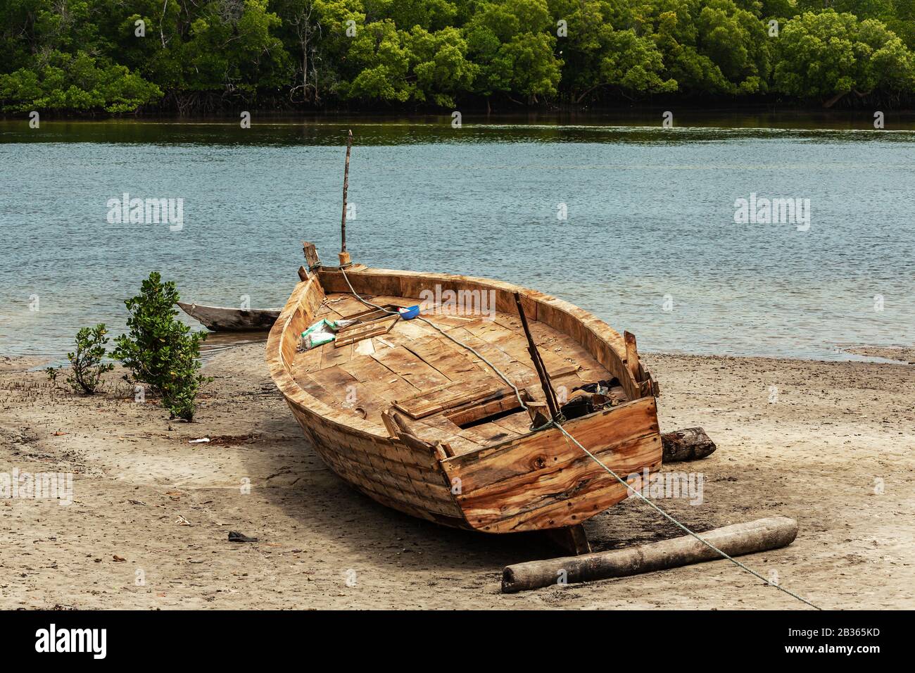 Pesca barca in legno su una spiaggia vicino mangrovie in Kenya Foto Stock