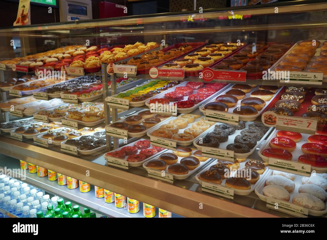 Varietà di ciambelle deliziose in vetrina presso il panificio Krispy Kreme. Vari tipi di ciambelle sul ripiano nel negozio di prodotti da forno. Selezione di dolci. Foto Stock Varietà di ciambelle deliziose in vetrina presso il panificio Krispy Kreme. Vari tipi di ciambelle sul ripiano nel negozio di prodotti da forno. Selezione di dolci. Foto Stock