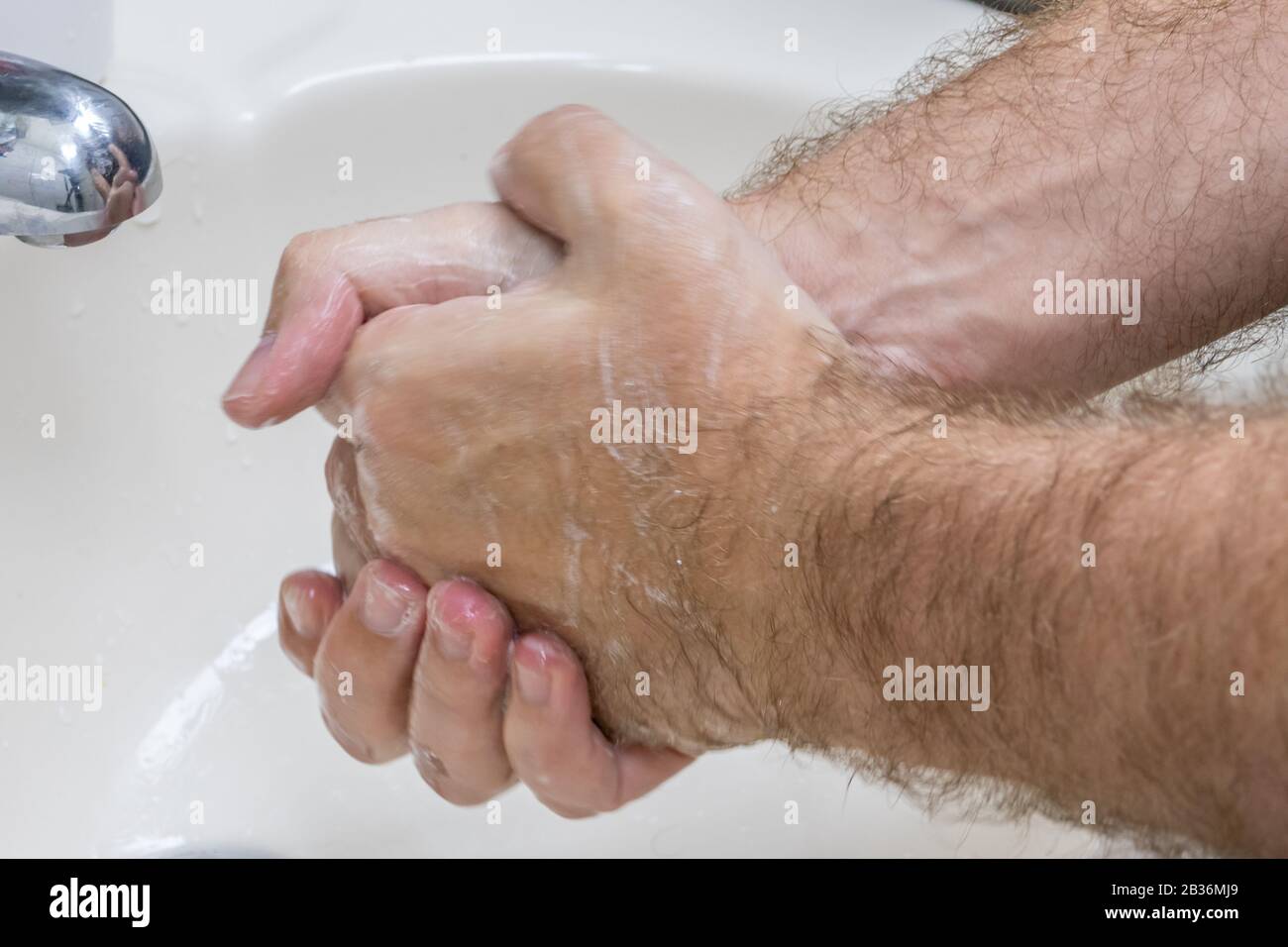 Uomo lavando le mani in primo piano lavabo, uno di diversi in serie handwashing steps Foto Stock
