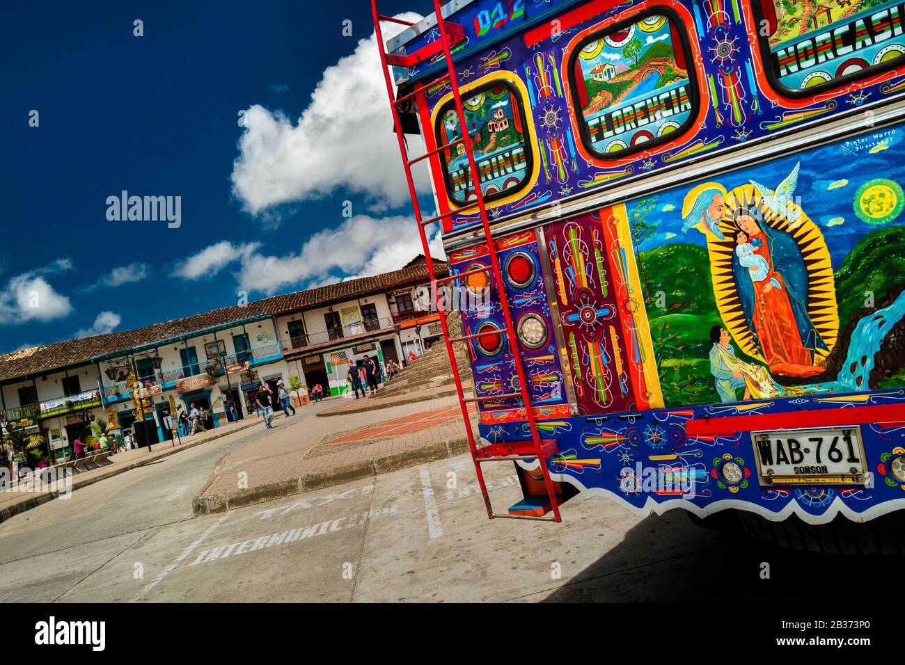 Un autobus rustico, dipinto in colori vivaci, chiamato localmente ‘scala mobile’, è visto parcheggiato nella piazza principale di Sonsón, Colombia. Foto Stock