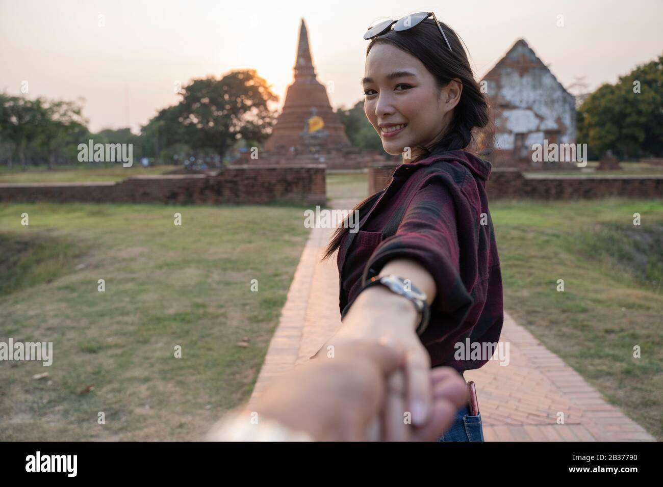 Seguimi al tempio, ayutthaya thailandia. Femmina turistico che conduce il ragazzo al tempio tailandese. Concetto di viaggio delle persone. Foto Stock