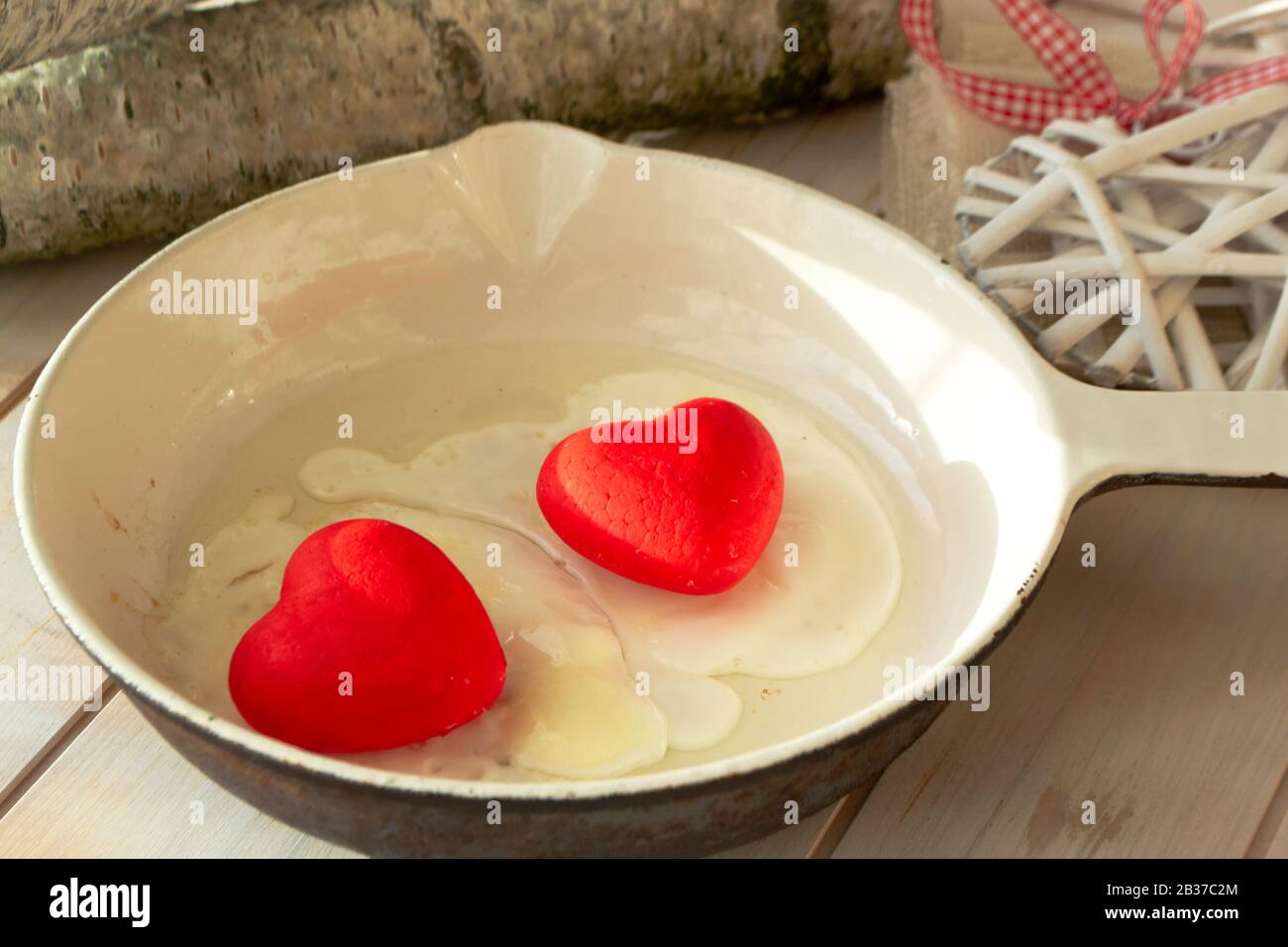 Uova fritte con cuori rossi su una padella bianca. Forma del cuore. Concetto di amore romantico. Un buon inizio di giornata. Foto Stock