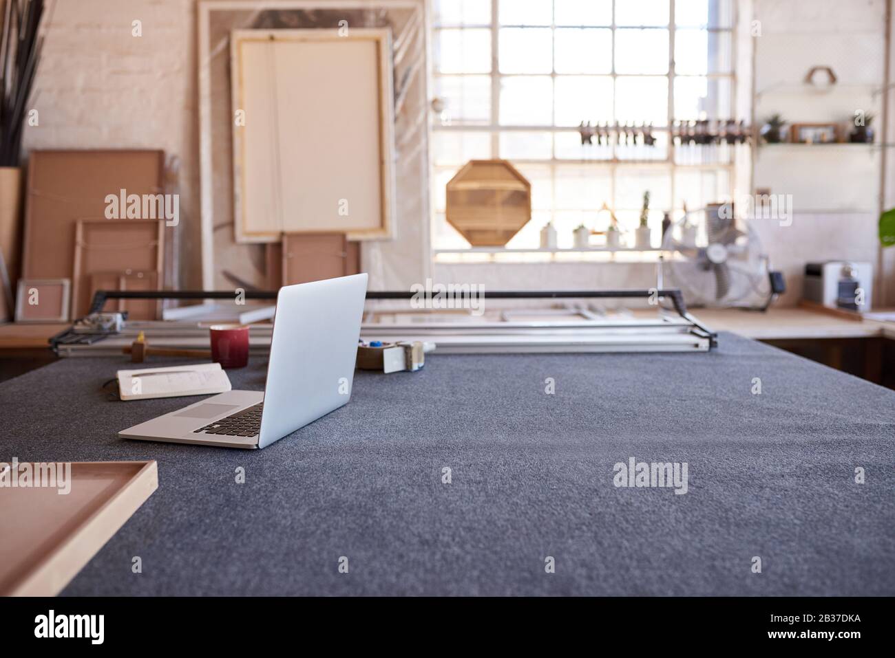 Laptop e mat cutter su un tavolo da lavoro Foto Stock