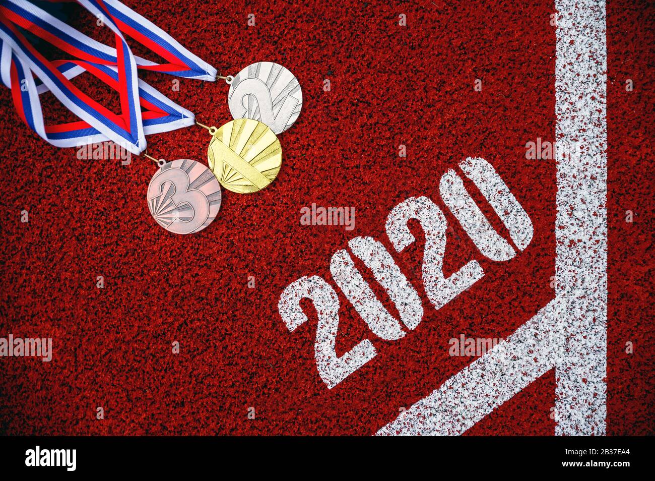 Medaglia fissata sulla pista di atletica rossa, sfondo sportivo per l'anno 2020. Evento Multi-Sport Foto Stock