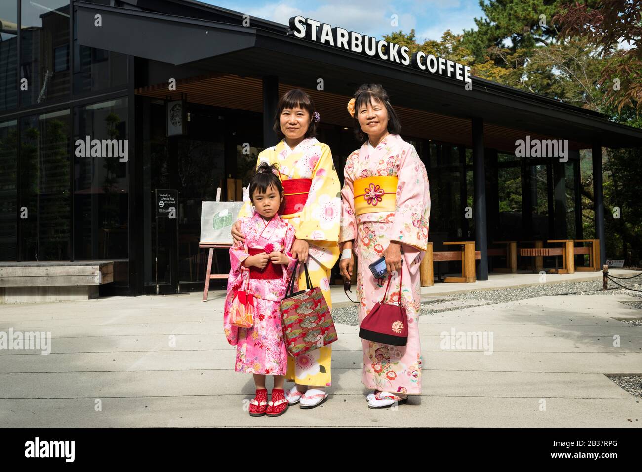 Apparentemente tre generazioni di donne che indossano kimono (che può essere assunto per il giorno) da uno Starbucks vicino ai terreni di Byodo-in, un tempio a Uji Foto Stock