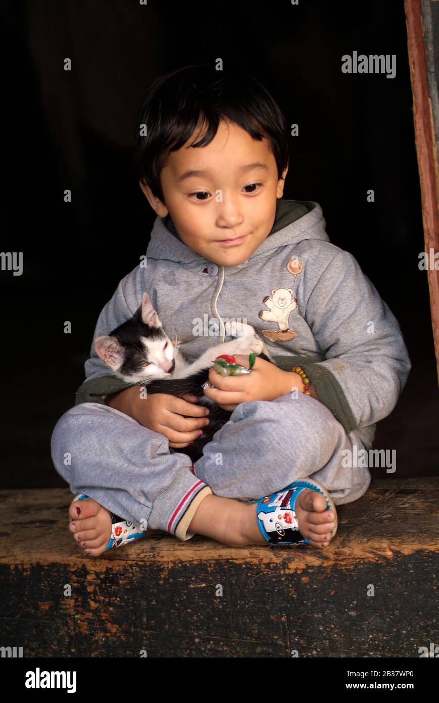 Paro, Bhutan - 18 settembre 2007: Bambina non identificata con gatto a Paro Dzong Foto Stock