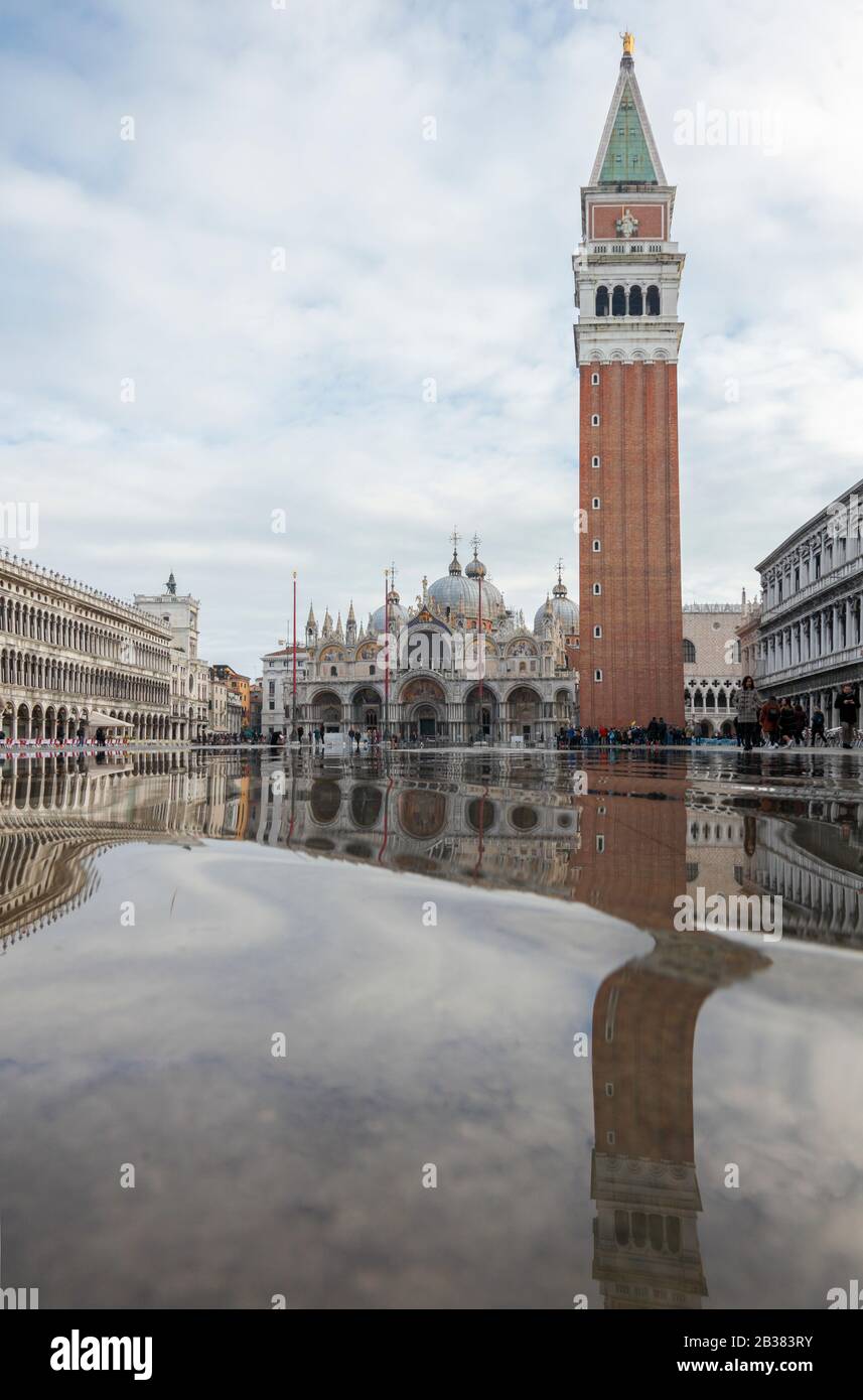 La Basilica di San Marco e la torre campanaria si riflettono nell'alta acqua di Piazza San Marco; Venezia; Veneto; Italia Foto Stock