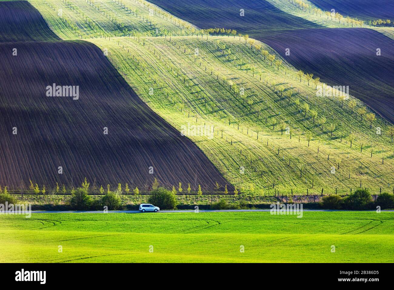 Paesaggio rurale con auto e campi agricoli sulle colline di primavera in Moravia del sud regione, Repubblica Ceca Foto Stock