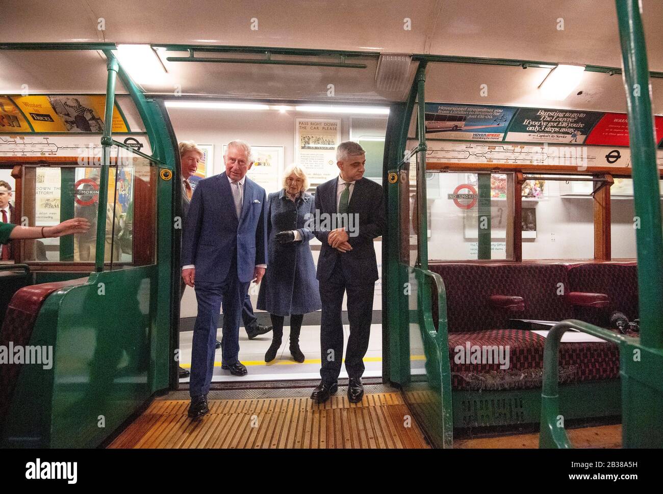 Il Principe di Galles e la Duchessa di Cornovaglia con il Sindaco di Londra Sadiq Khan (a destra) salire su una vecchia carrozza metropolitana di Londra durante una visita al London Transport Museum per segnare 20 anni di trasporto per Londra. Foto Stock