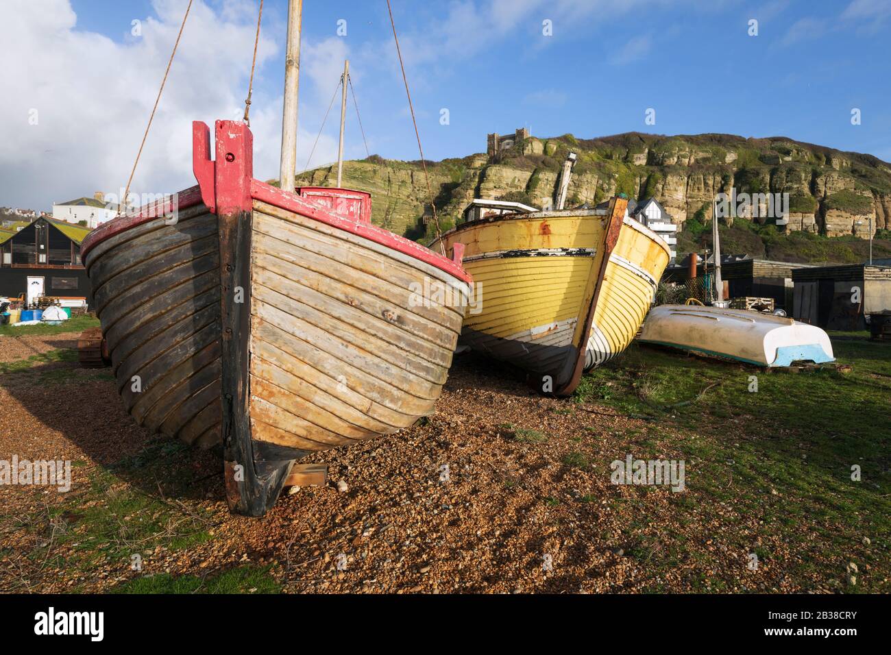 Vecchie barche da pesca in legno sulla spiaggia allo Stade con East Hill dietro, Hastings, East Sussex, Inghilterra, Regno Unito, Europa Foto Stock