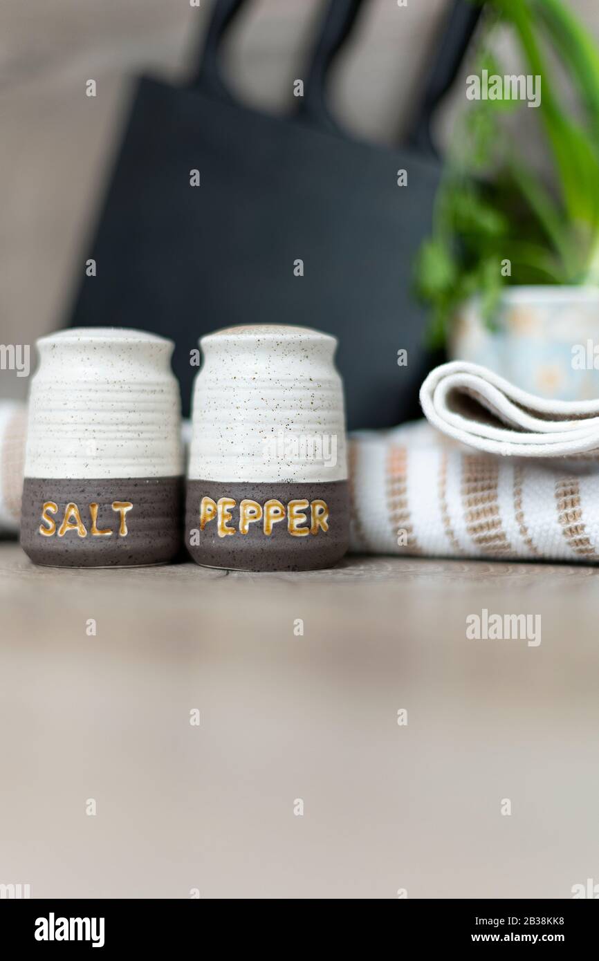 Agitatori con sale e pepe sullo spazio di lavoro della cucina. Foto Stock