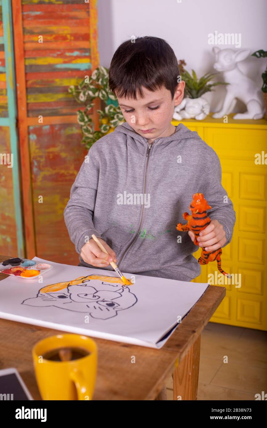 Ragazzo con pennello che dipinge una tigre Foto Stock