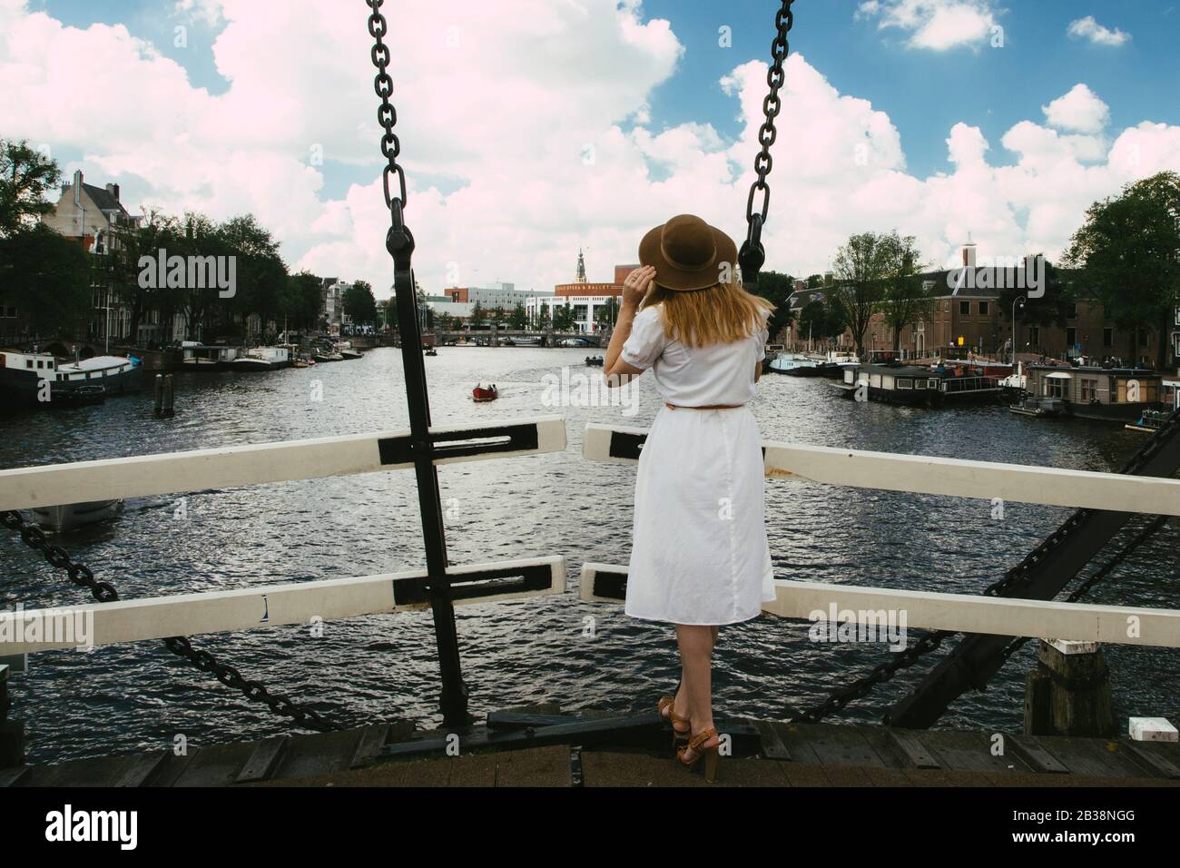 donna sul ponte che guarda sul canale Foto Stock