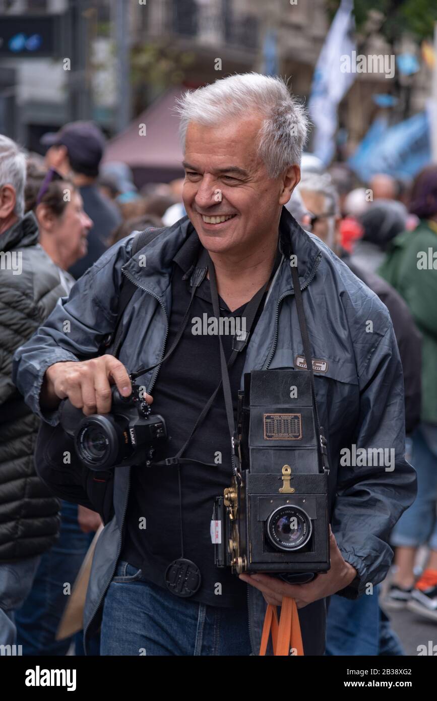 Uomo che cammina con una vecchia macchina fotografica alla manifestazione Popolare la memoria, la verità e la giustizia della Giornata Nazionale Foto Stock