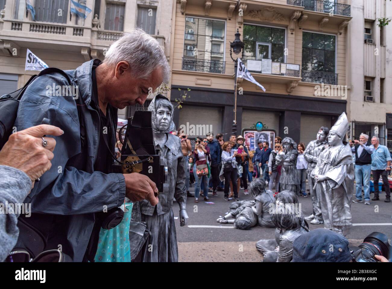 Uomo che scatta foto con una vecchia macchina fotografica alle espressioni artistiche alla manifestazione Popolare la memoria, la verità e la giustizia della Giornata Nazionale Foto Stock