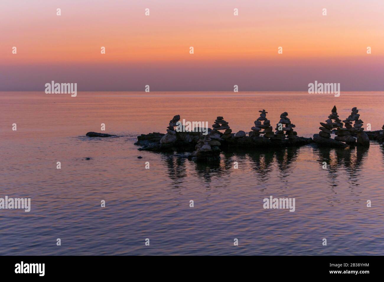 Rilassante tramonto di mare rosa con pietre. Foto Stock