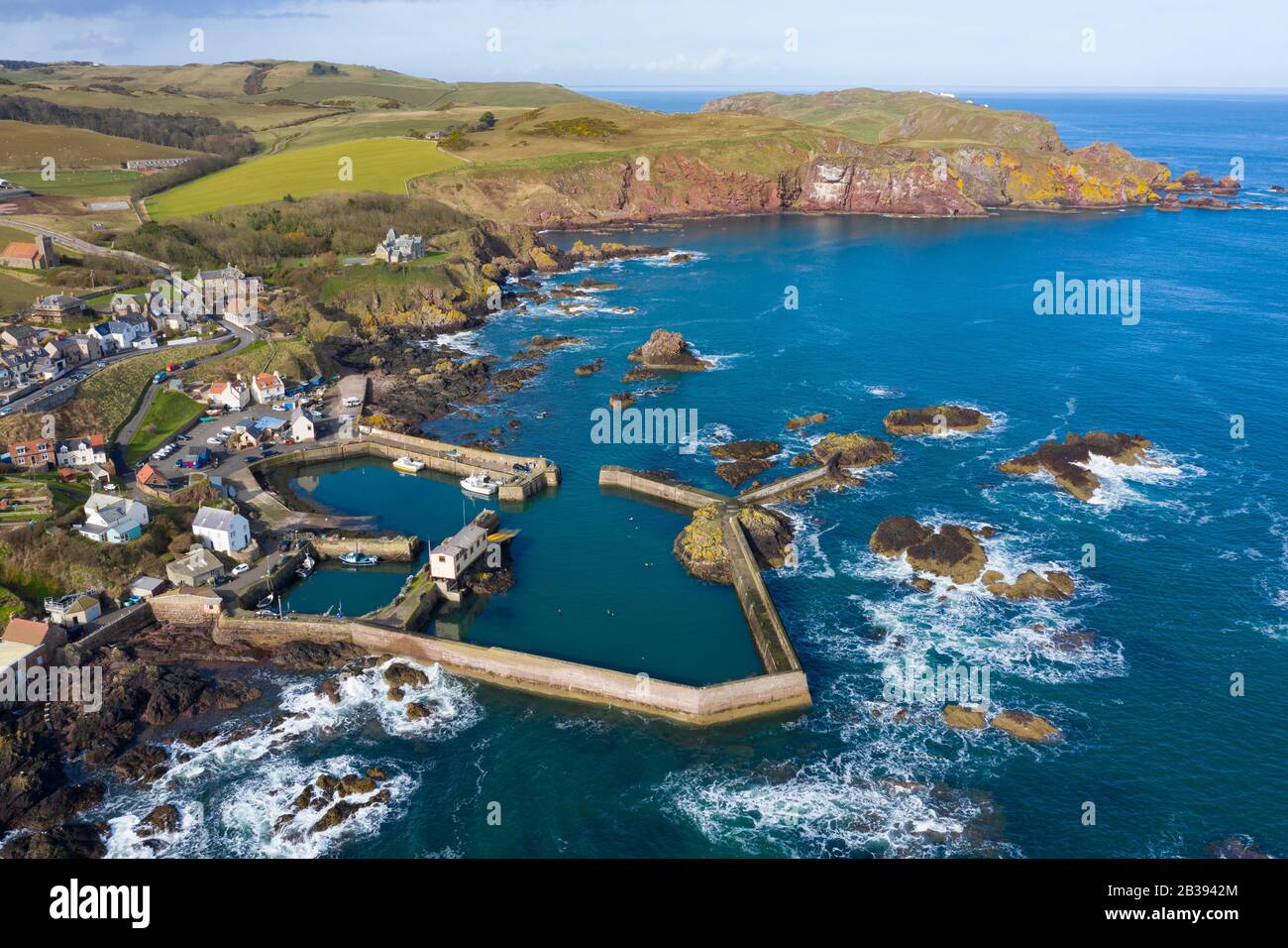 Veduta aerea del piccolo villaggio di pescatori e del porto di St Abbs sulla costa del Mare del Nord nei Confini scozzesi, Scozia, Regno Unito Foto Stock