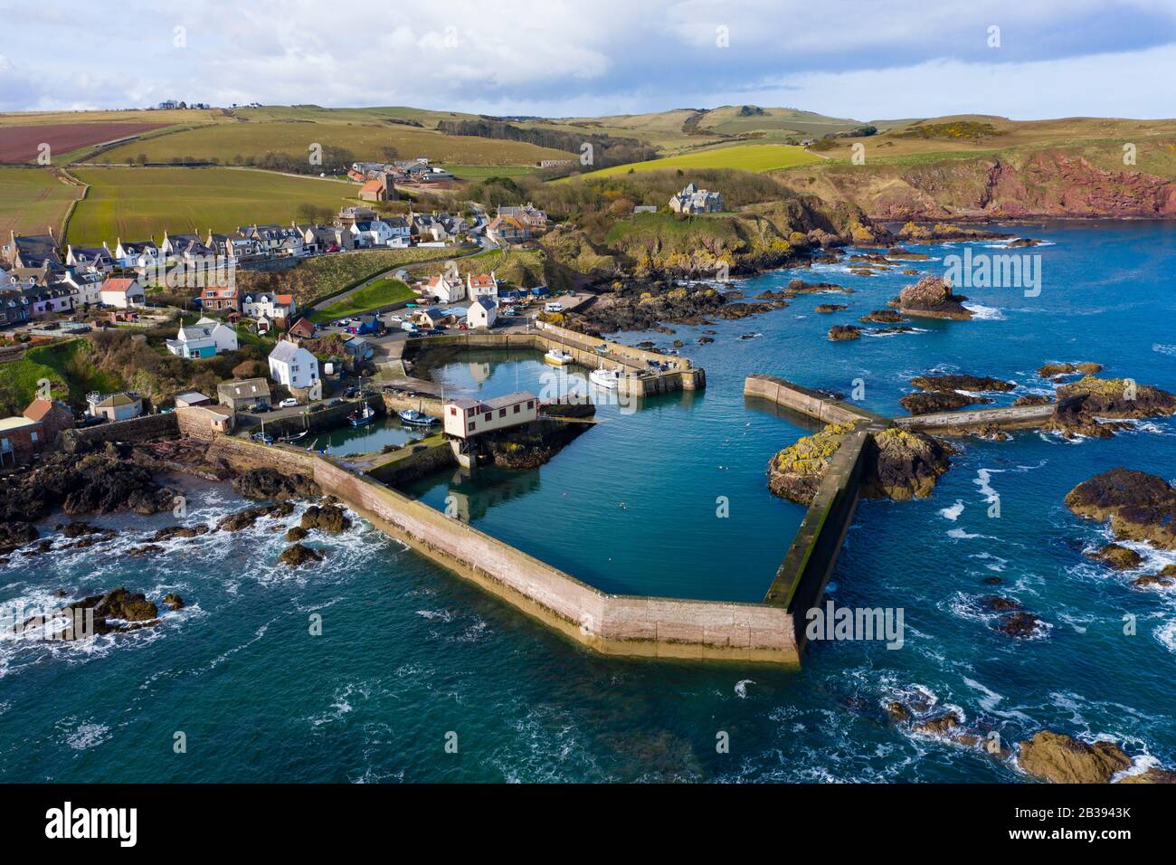 Veduta aerea del piccolo villaggio di pescatori e del porto di St Abbs sulla costa del Mare del Nord nei Confini scozzesi, Scozia, Regno Unito Foto Stock