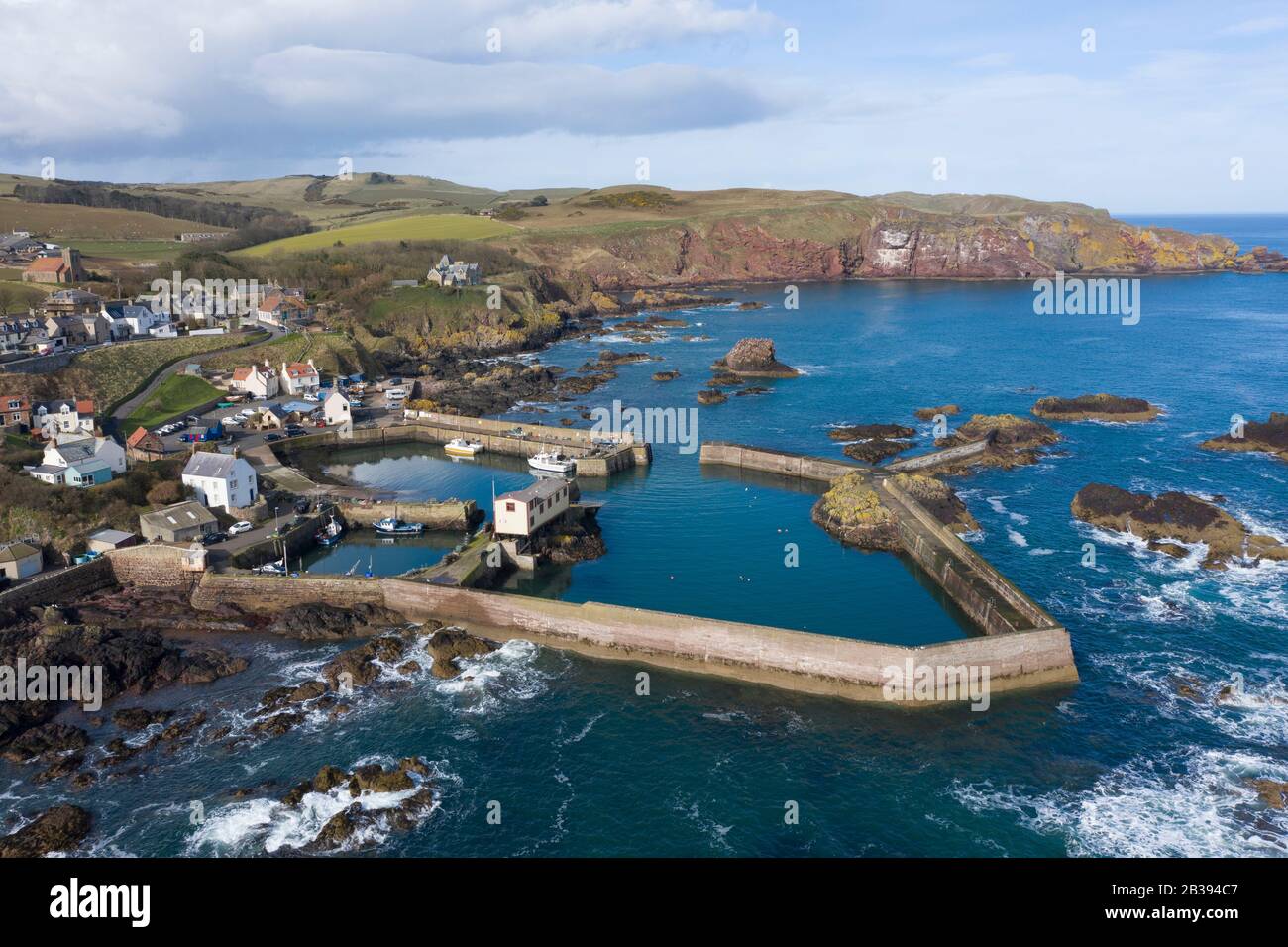 Veduta aerea del piccolo villaggio di pescatori e del porto di St Abbs sulla costa del Mare del Nord nei Confini scozzesi, Scozia, Regno Unito Foto Stock