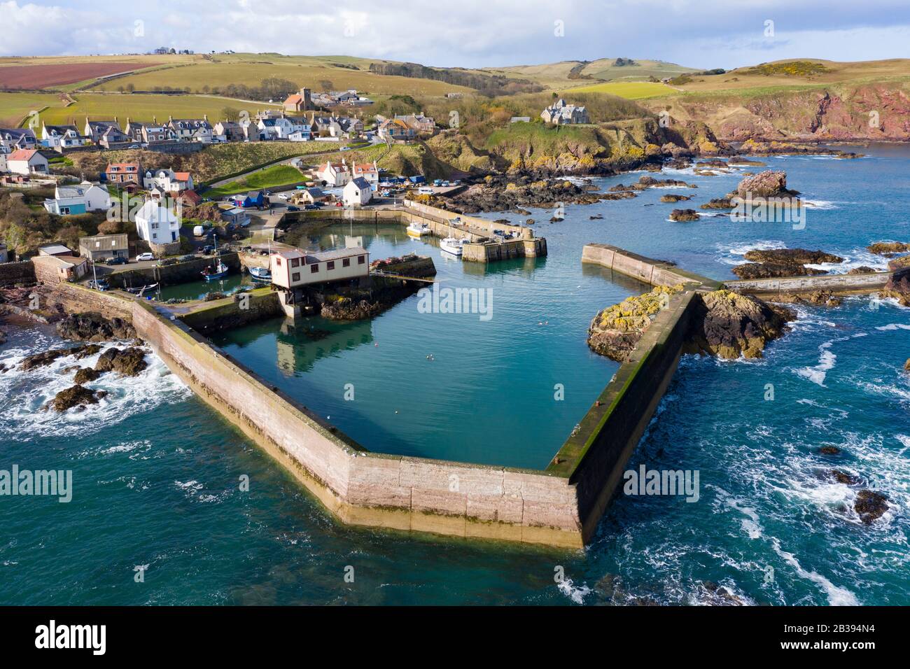 Veduta aerea del piccolo villaggio di pescatori e del porto di St Abbs sulla costa del Mare del Nord nei Confini scozzesi, Scozia, Regno Unito Foto Stock
