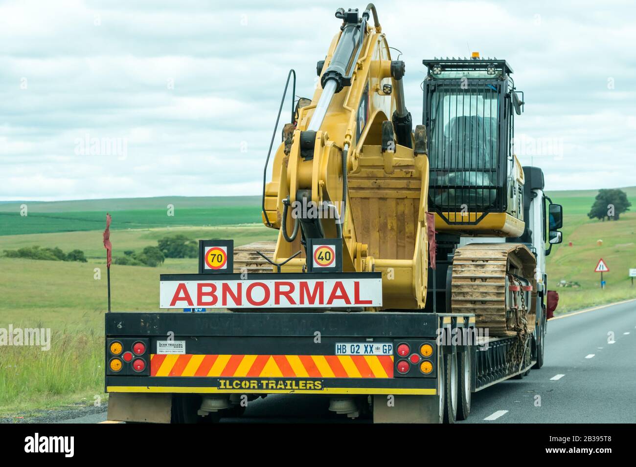 Ostruzione di un autocarro con carico anomalo che trasporta un veicolo industriale pesante su un'autostrada in Sud Africa Foto Stock
