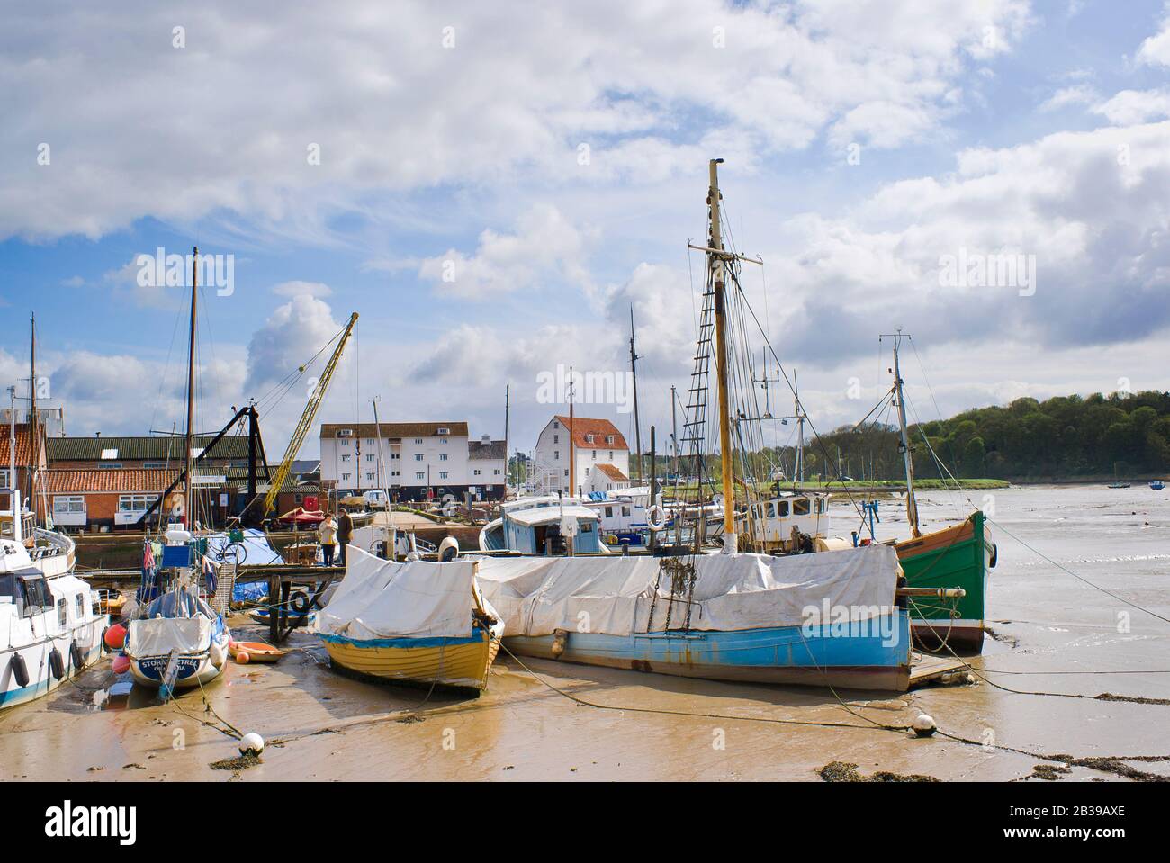 La bassa marea lascia piccole barche bloccate nel porto di Woodbridge sul fiume Deben nel Suffolk Inghilterra UK Foto Stock